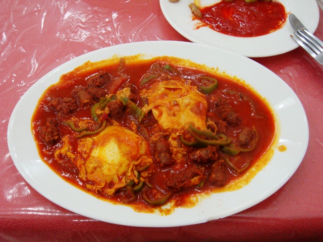 Ojja tunisina piccante con uova in camicia e pomodoro.