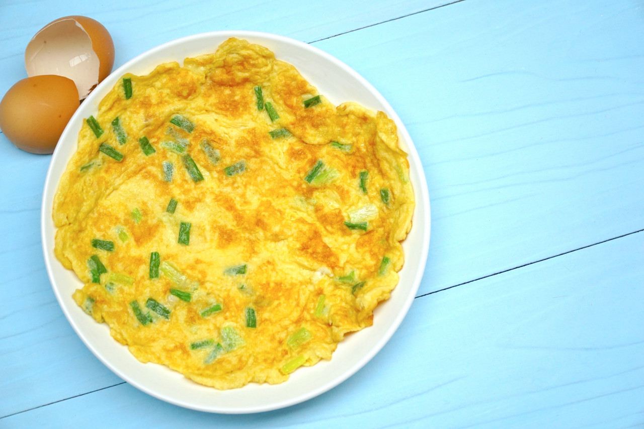 omelette with green onion blue wood table