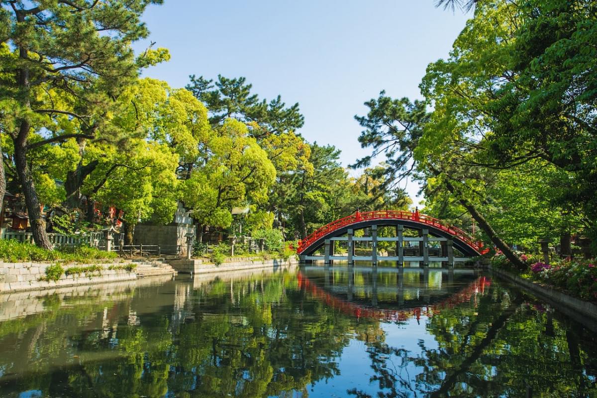 oriental park with footbridge over canal on sunny day