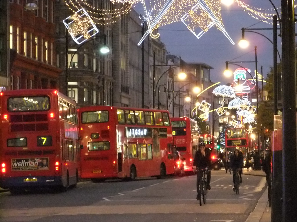 Luminarie natalizie a Regent Street con un bus rosso di Londra in transito