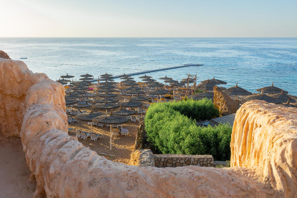 panoramic view beach ras umm el sid beautiful sunrise red sea with rocky shores sandy beach with umbrellas first rays sun sharm el sheikh egypt vacation holiday concept