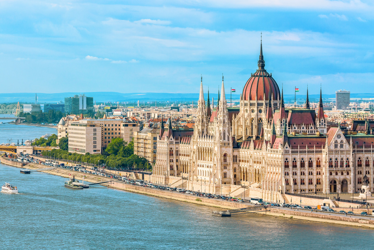 parliament riverside budapest hungary with sightseeing ships during summer day with blue sky clouds