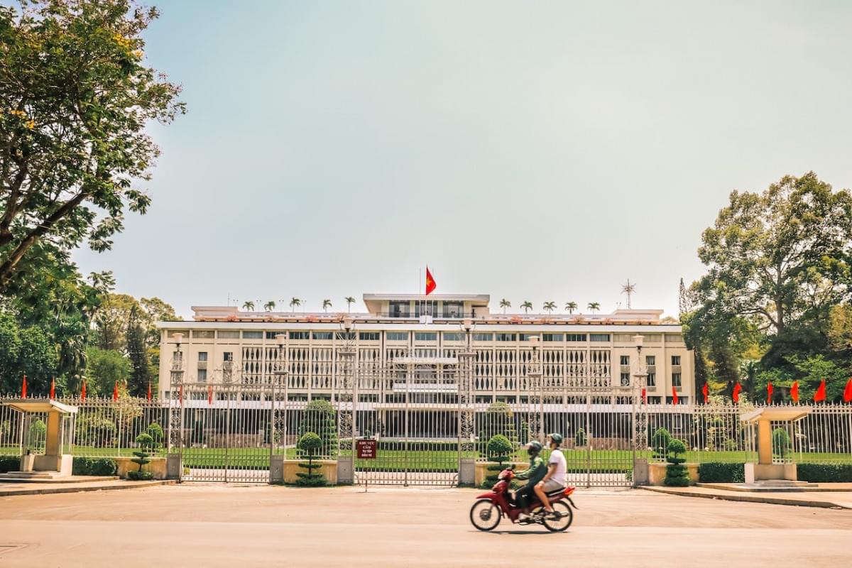 people on a motorcycle near the independence palace in vietnam 1 1