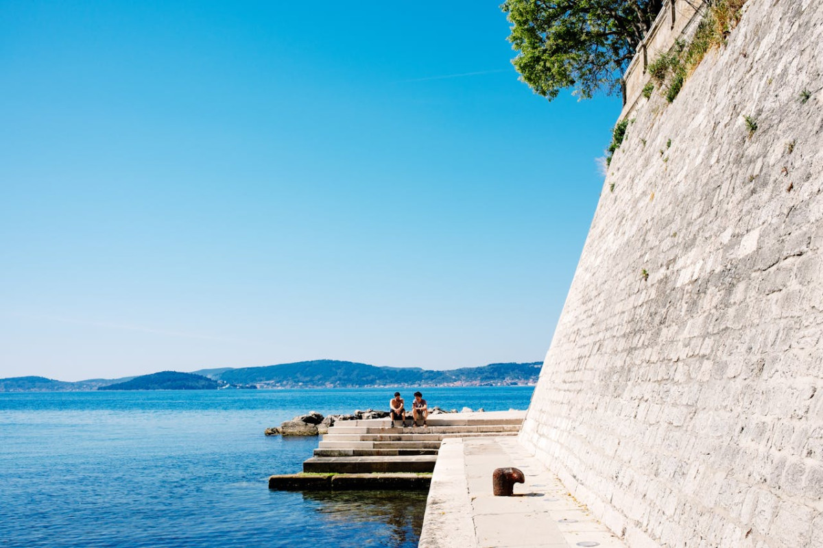 people sitting on seashore in zadar in croatia