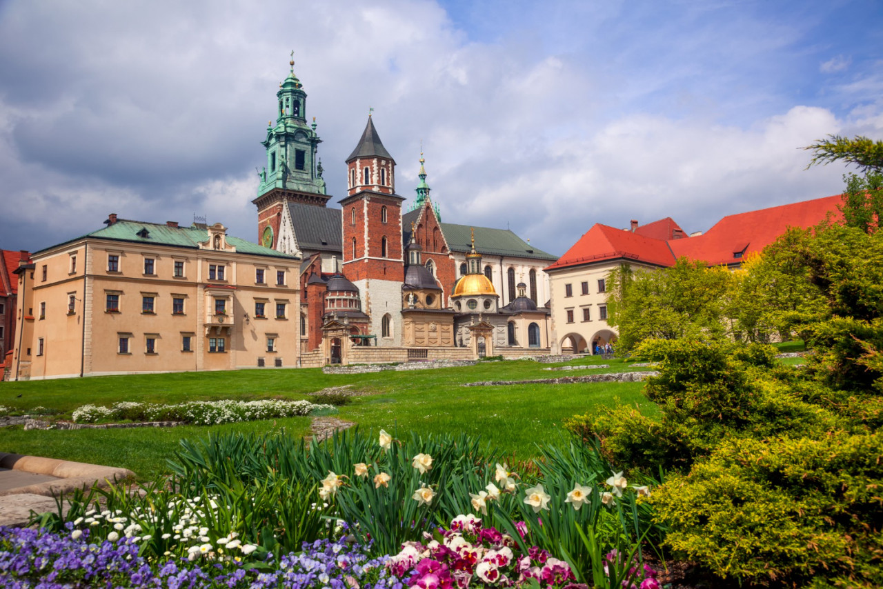 poland krakow wawel castle blooming park domes cathedral against cloudy sky