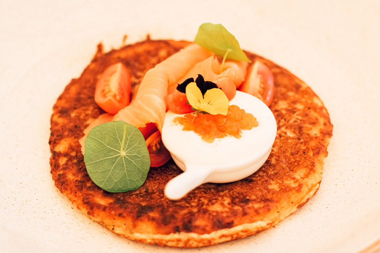 potato fritter pancake with red caviar salmon sour cream luxury restaurant outdoors summer