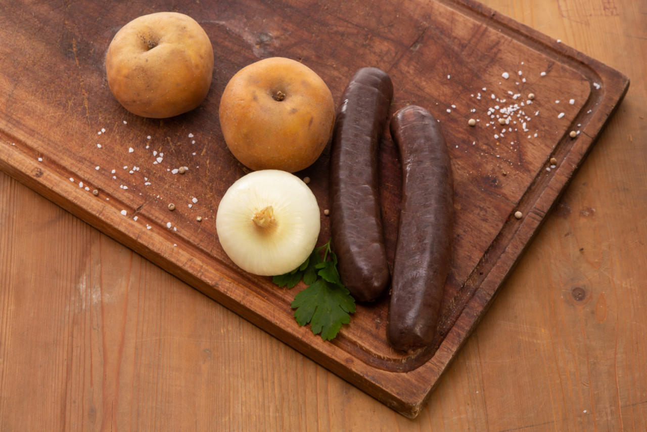 raw apple pudding black pudding wooden cutting board