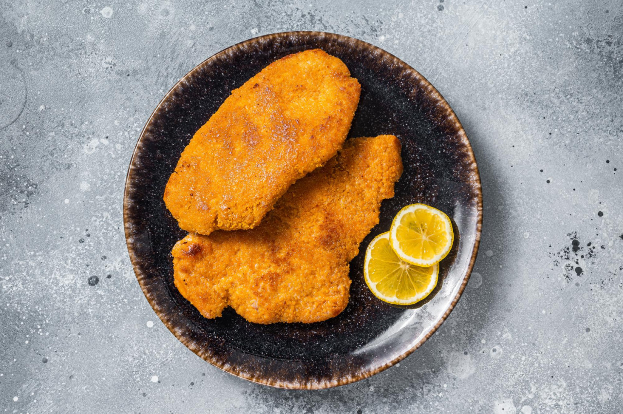 roasted breaded german weiner schnitzel plate gray background top view