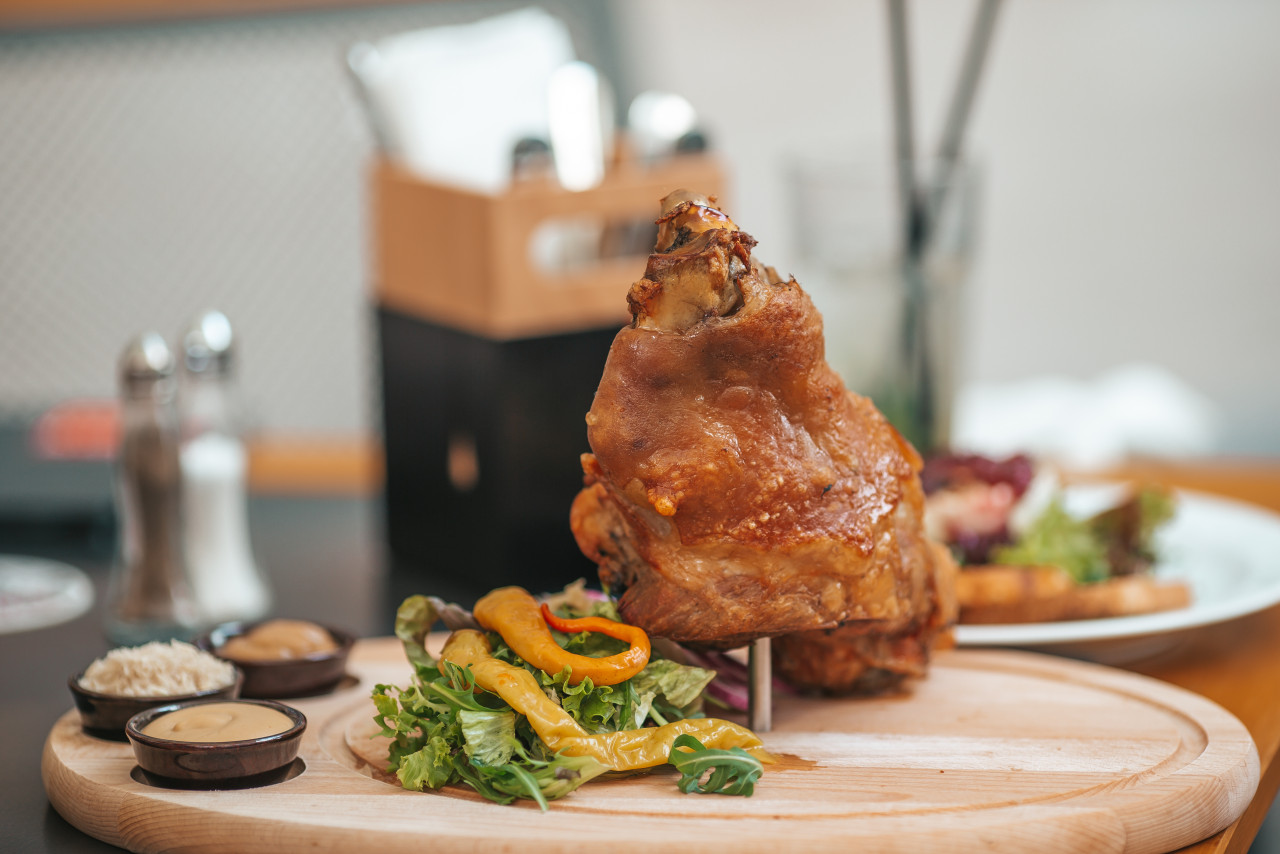 roasted pork knuckle eisbein with salad mustard wooden cutting board