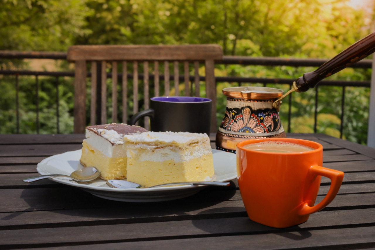 rustic breakfast wooden coffee table with coffee cups cezve lake bled cream cake delicious slovenian dessert kremna rezina cremeschnitte