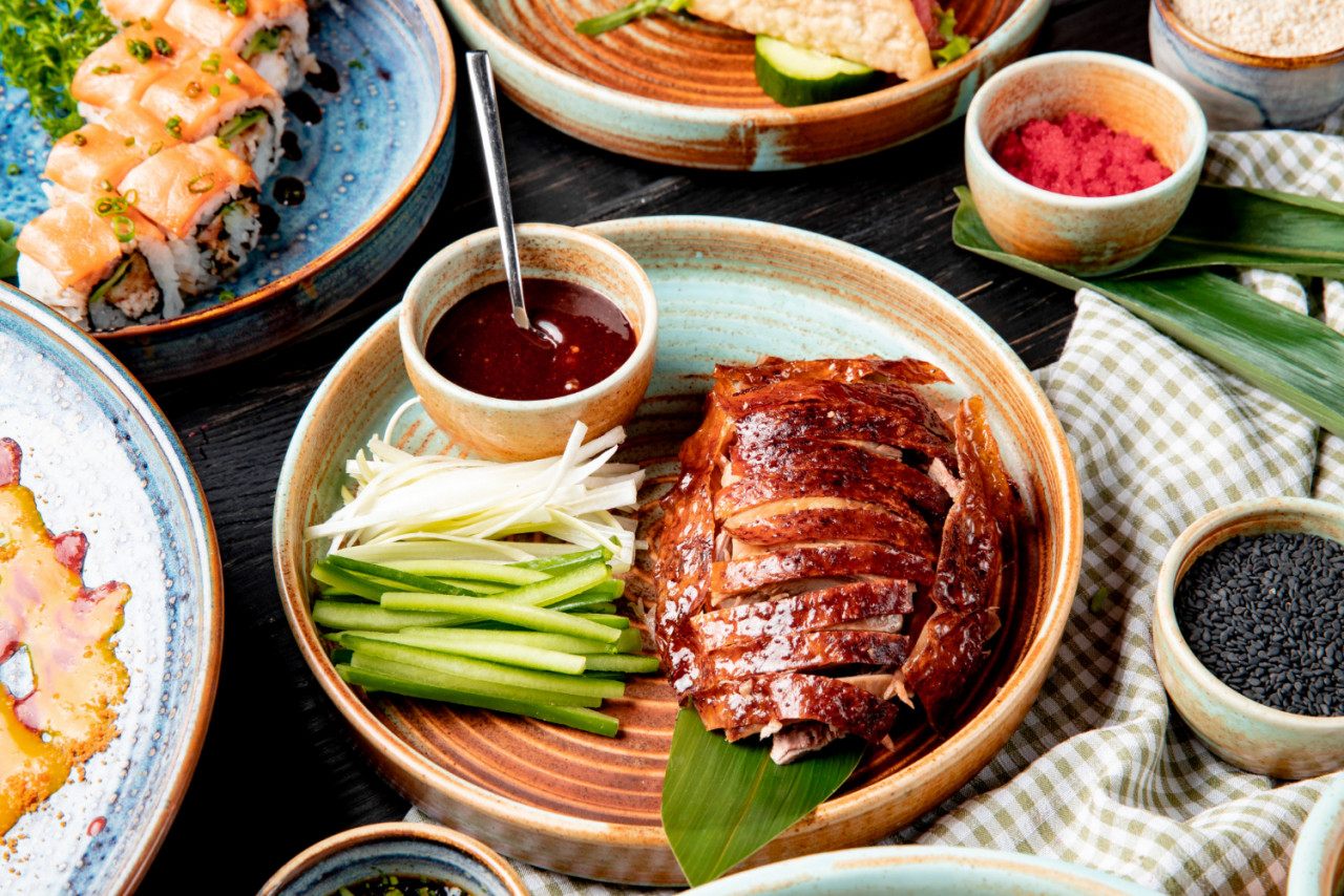 side view traditional asian food peking duck with cucumbers sauce plate