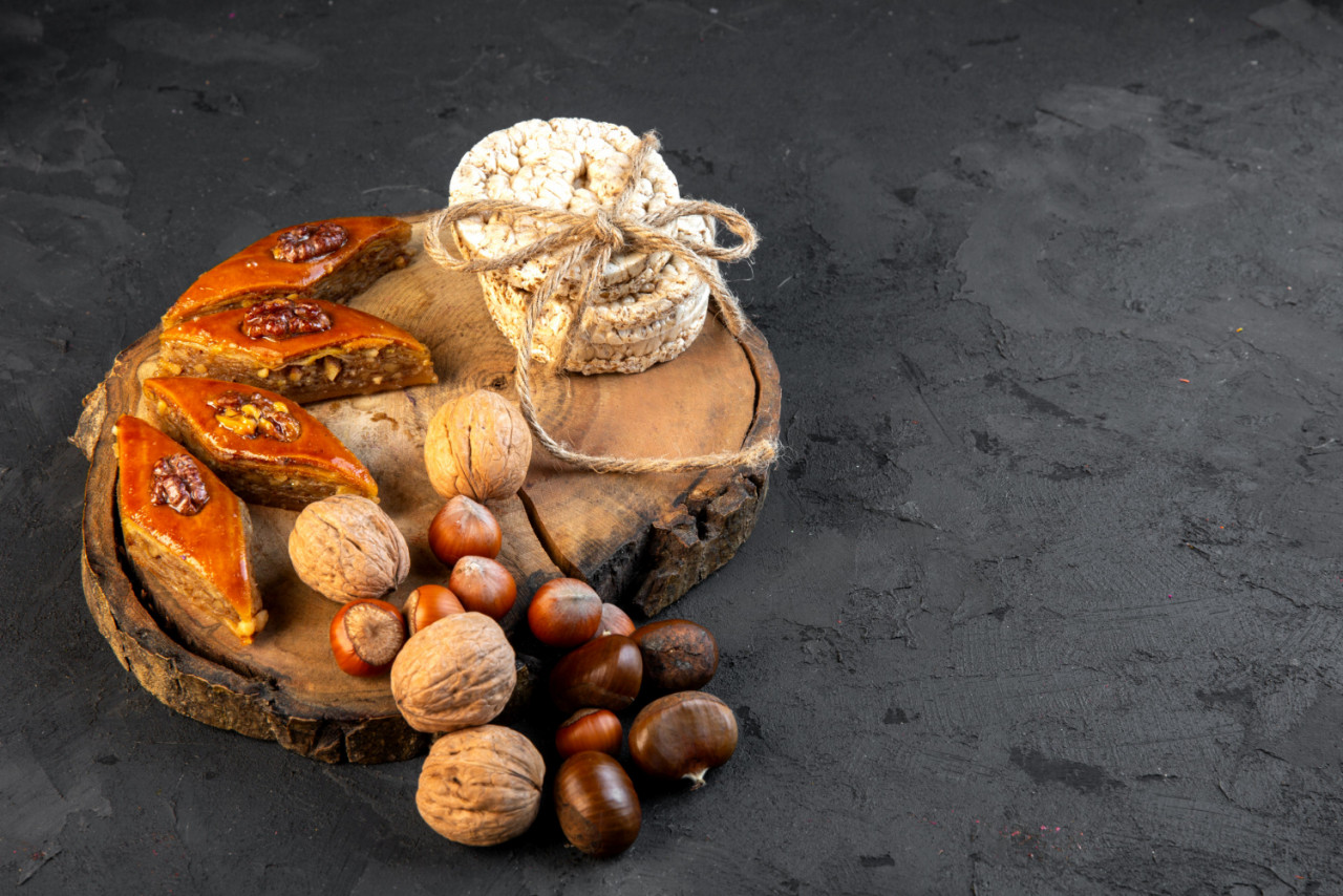 side view traditional azerbaijani baklava with nuts rice breads wooden board black