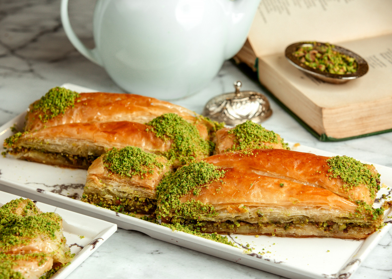 side view turkish sweets triangular shapedbaklava with pistachio platter