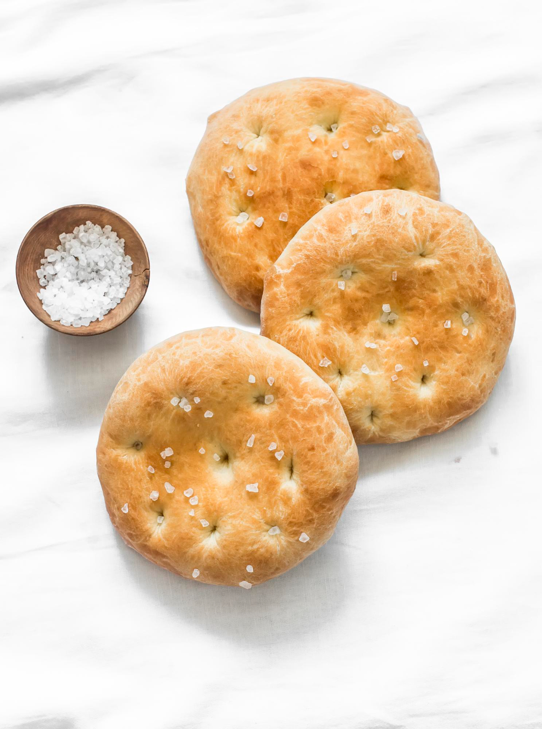 small focaccia tortillas with sea salt light background top view