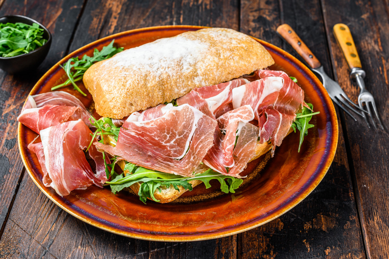 spanish bocadillo de jamon serrano ham sandwich ciabatta bread with arugula dark wooden background top view