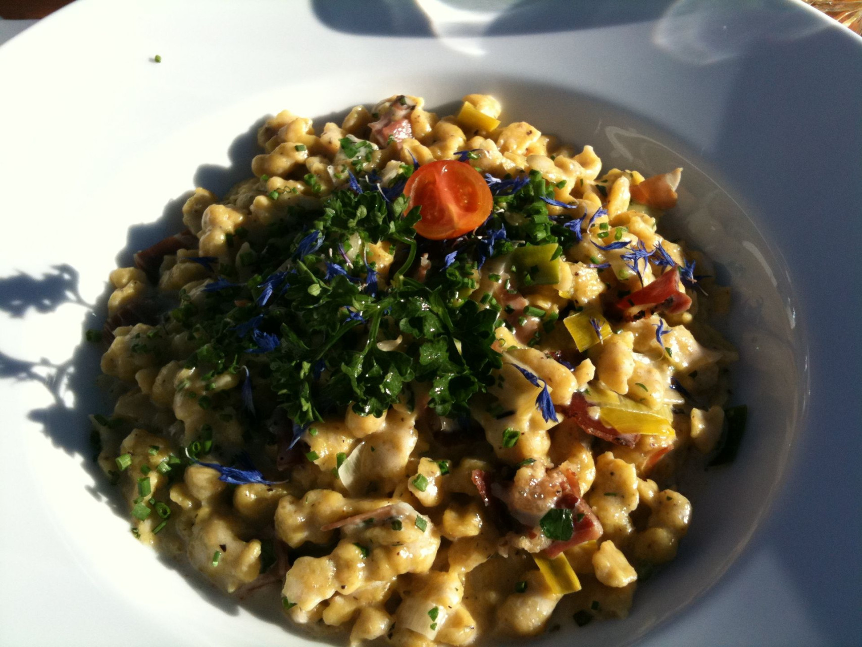 spatzle con speck porro e fiori di montagna con salsa al vino bianco