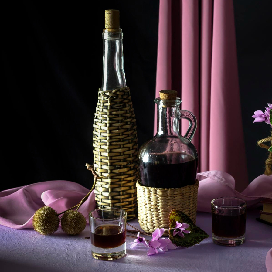 still life with homemade liquor wild cyclamen table closeup