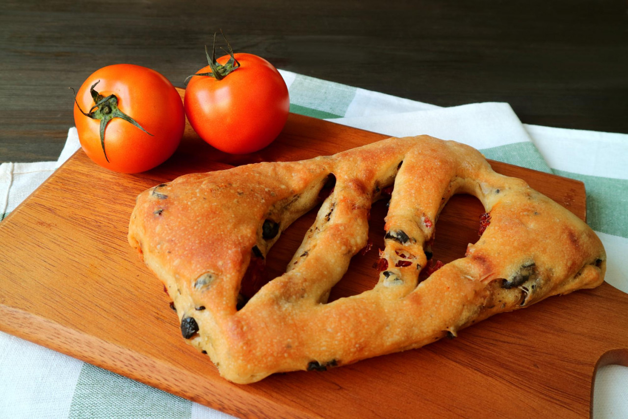 sun dried tomato olive fougasse french bread with pair fresh tomatoes wooden tray