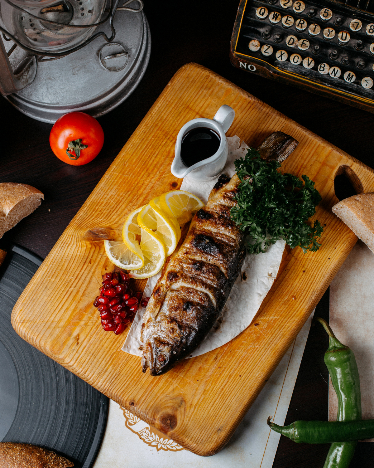 top view grilled trout with lemon pomegranate seeds wooden cutting board