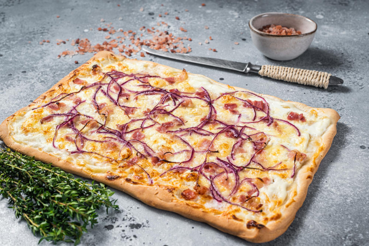 traditional german flammkuchen pie with ham onion gray background top view