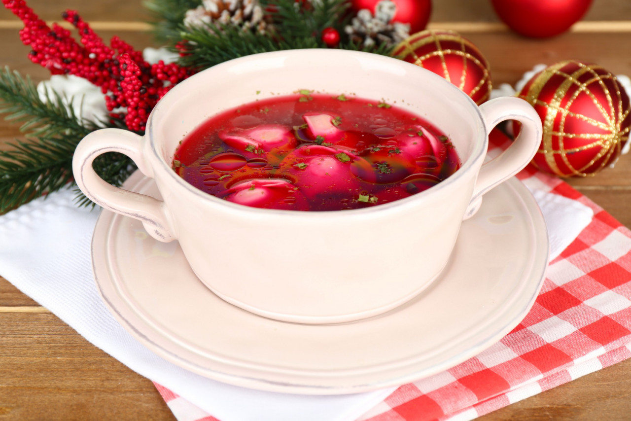 traditional polish clear red borscht with dumplings christmas decorations wooden table surface