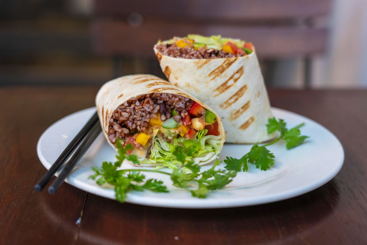 vegan burrito sliced up raw food wrap with vegan ingredients plate