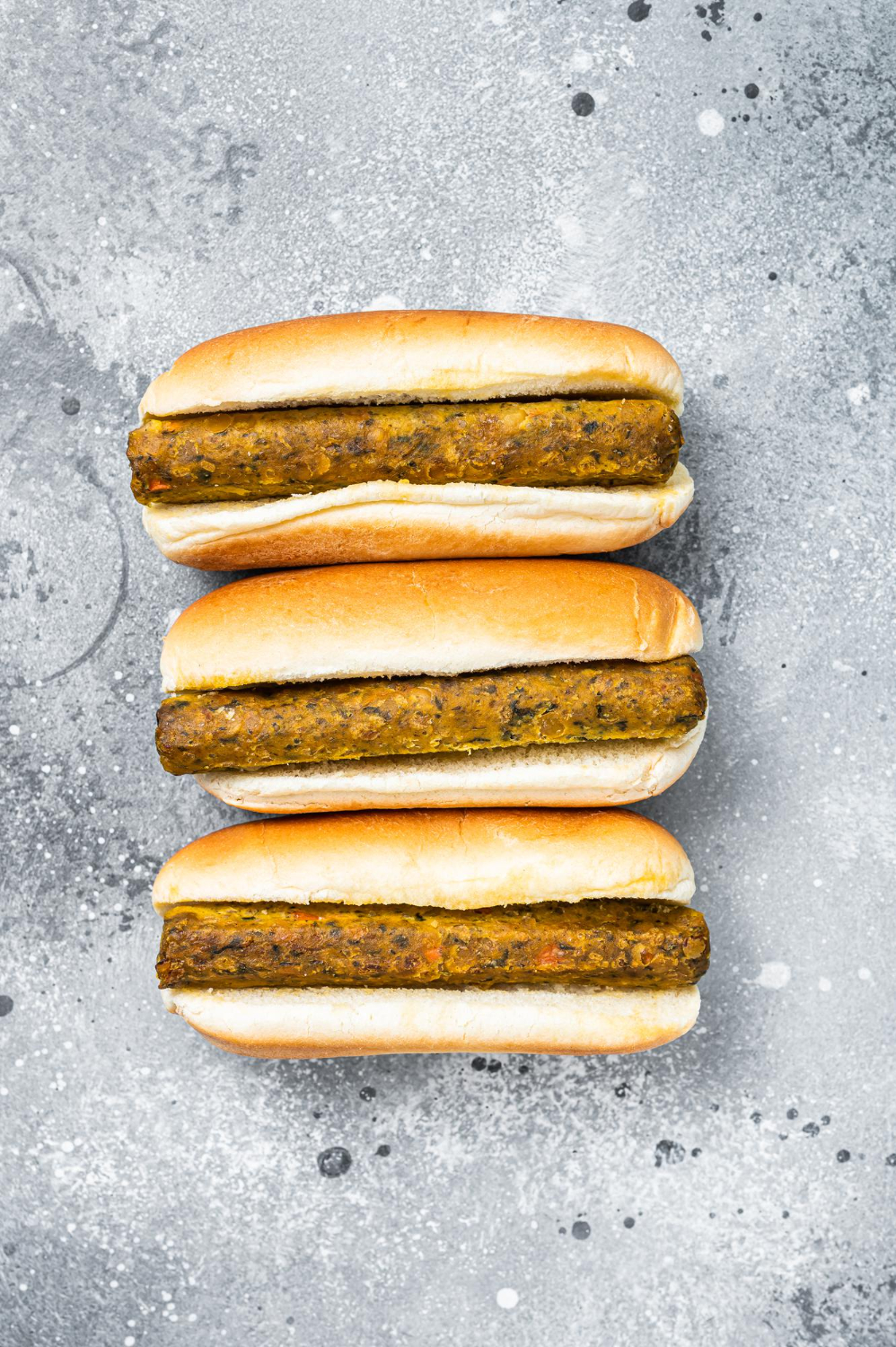 vegan hot dog with meatless vegetarian sausage gray background top view