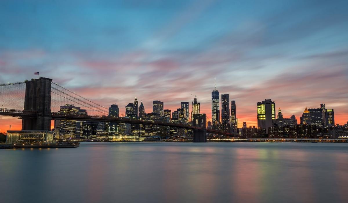 view of the brooklyn bridge and buildings in new york city at sunset 1