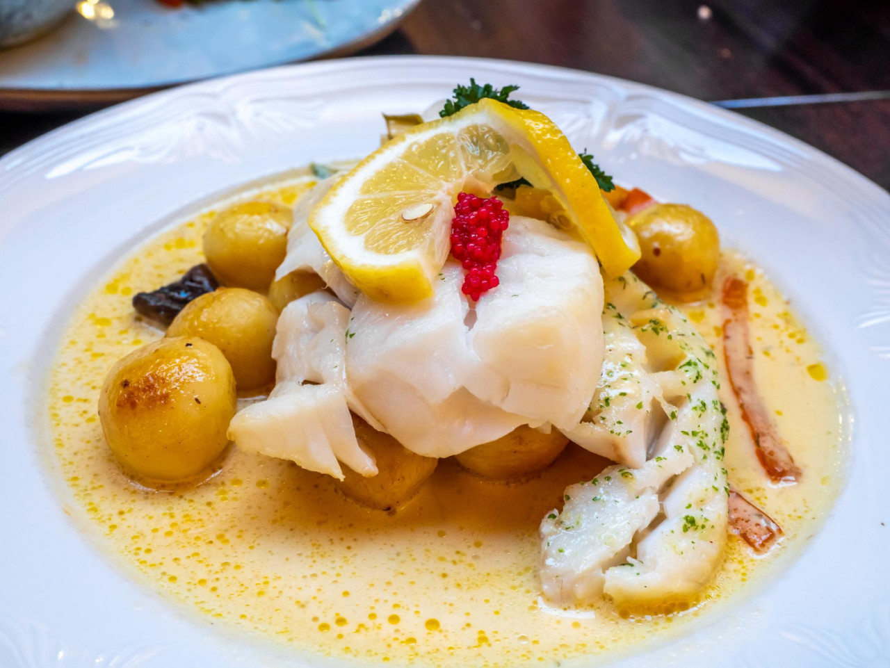 white cod fish with lemon berry cream sauce white dish iceland restaurant