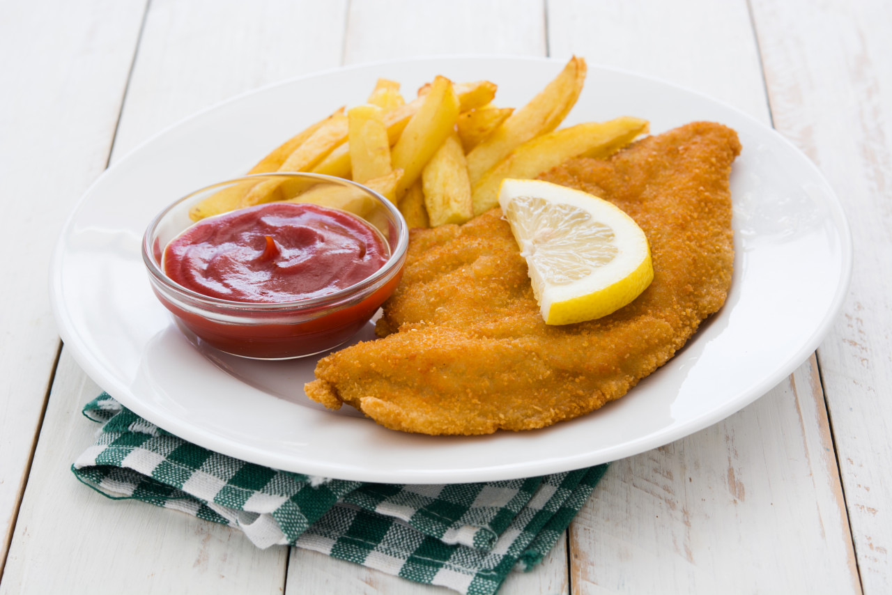 wiener schnitzel with fried potatoes white wooden