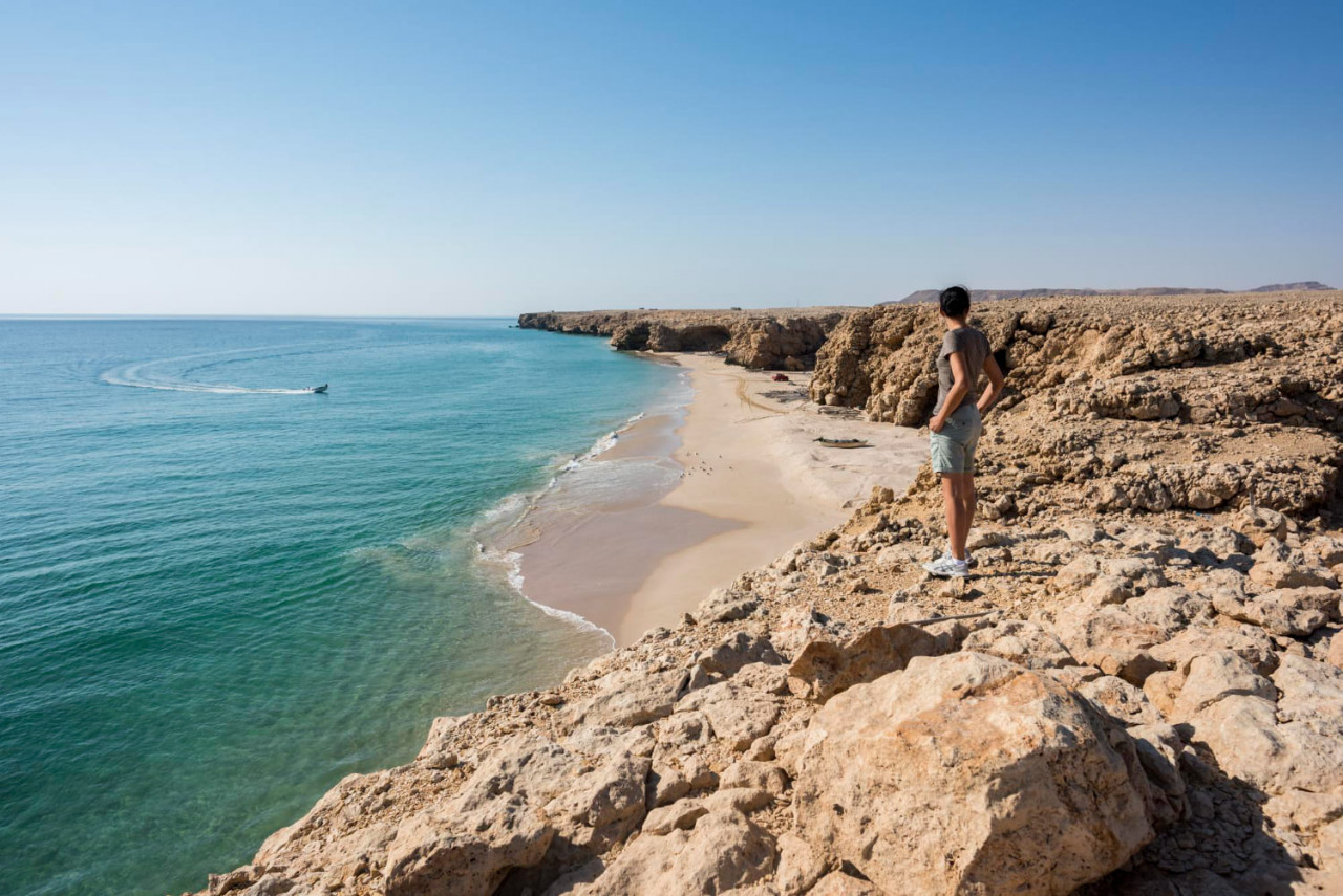 woman admiring wild beach coast ras al jinz sultanate oman