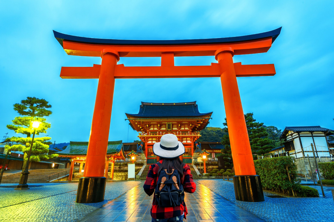 woman traveler with backpack fushimi inari taisha shrine kyoto japan