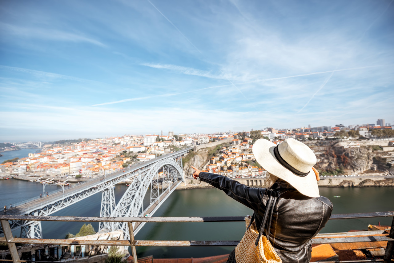 young woman tourist enjoying beautiful aerial cityscape view with famous bridge porto city portugal
