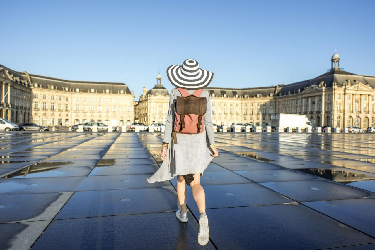 young woman tourist walking back famous water mirror fuontain bordeux city france